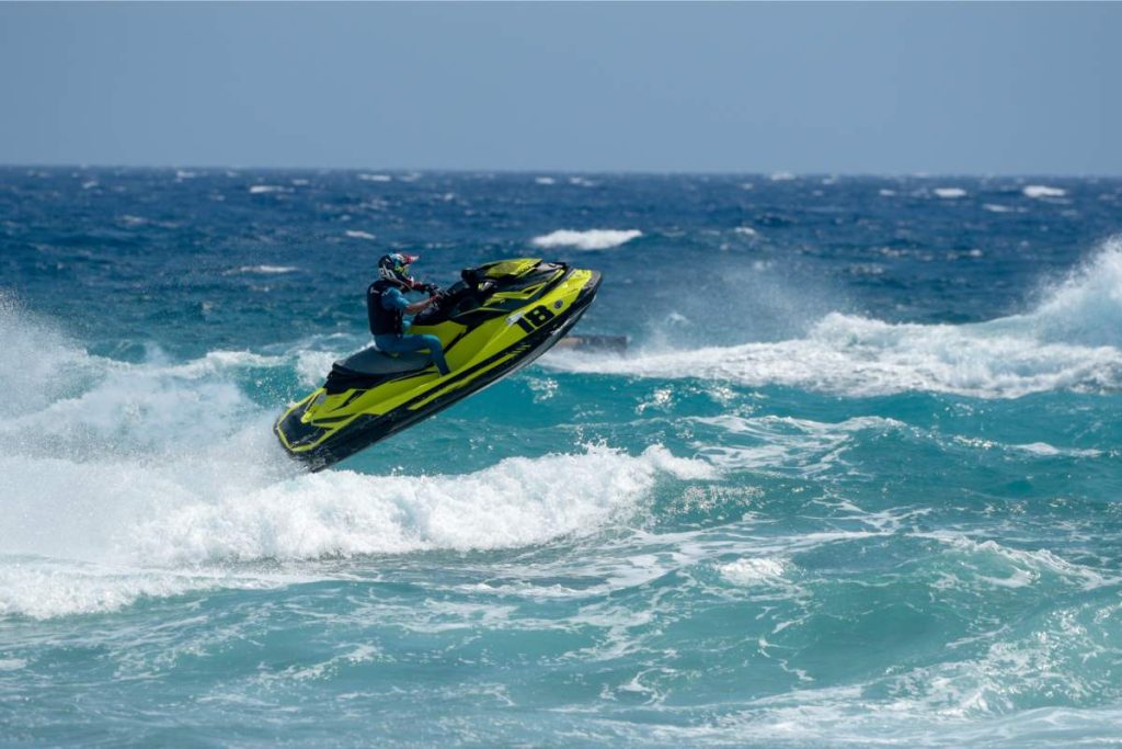 Man on water scooter, Jet ski against sea waves. Water sport competition.